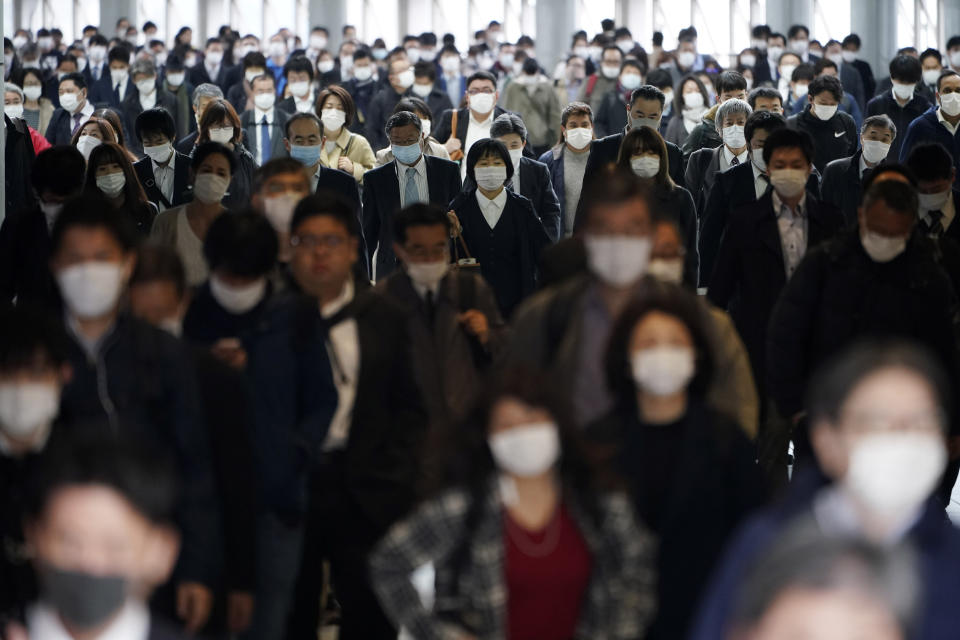 FILE - In this April 27, 2020, file photo, a station passageway is crowded with commuters wearing face mask in Tokyo. Under Japan's coronavirus state of emergency, people have been asked to stay home. Many are not. Some still have to commute to their jobs despite risks of infection, while others are dining out, picnicking in parks and crowding into grocery stores with scant regard for social distancing. (AP Photo/Eugene Hoshiko, File)