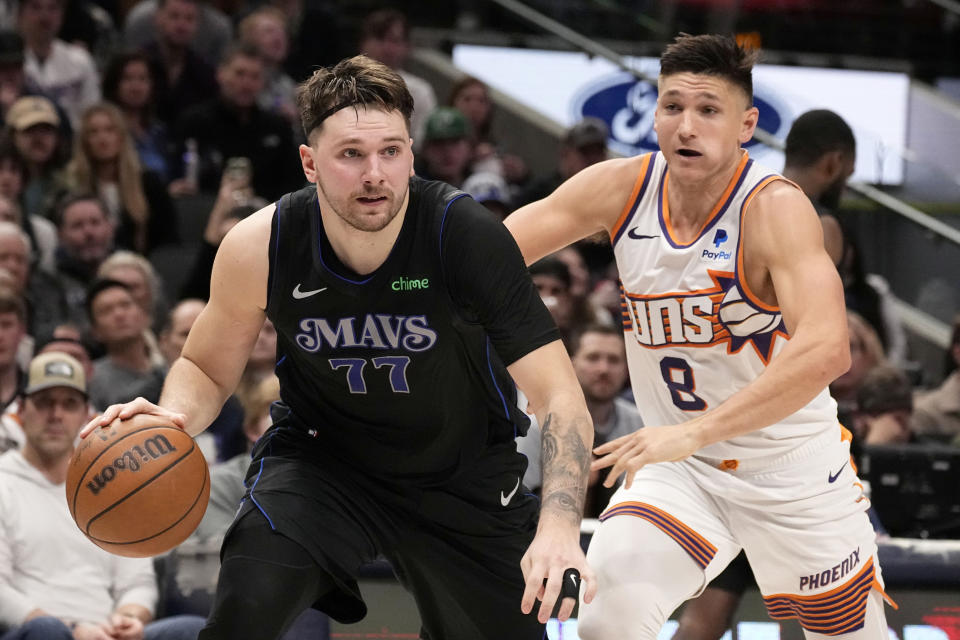 Dallas Mavericks guard Luka Doncic advances the ball up court in front of Phoenix Suns guard Grayson Allen (8) in the first half of an NBA basketball game in Dallas, Wednesday, Jan. 24, 2024. (AP Photo/Tony Gutierrez)