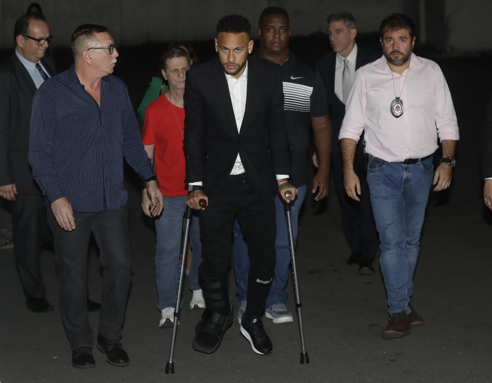 Using crutches because of an injured right ankle, Brazil's soccer player Neymar leaves a police station where he answered questions about rape allegations against him in Sao Paulo, Brazil, Thursday, June 13, 2019. Neymar denies any wrongdoing. (AP Photo/Andre Penner)