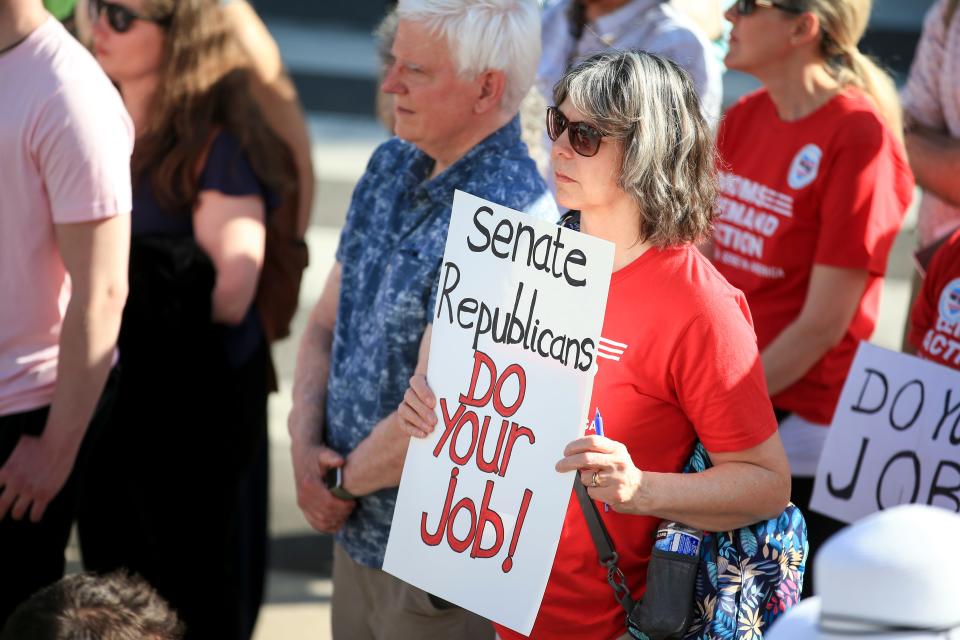 A woman at a protest Thursday holds a sign asking Republican senators to return to the Oregon Legislature. Republican lawmakers have said they're protesting a lack of readability of bill summaries, as well as Democratic legislation restricting gun use and expanding abortion and transgender protections.