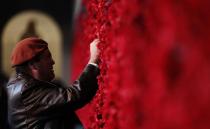 A member of the public places a poppy on the Roll of Honour in the Australian War Memorial. Source: Getty.