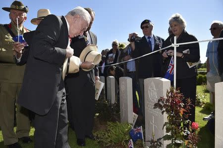 Australian World War Two veterans place crosses and flags at graves before attending the French-British ceremony at the British War cemetery in Bayeux, June 6, 2014. REUTERS/Leon Neal/Pool