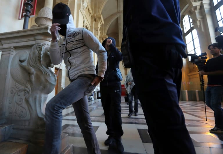 Witnesses cover their faces as they arrive for the trial of a jihadist network known as the "Cannes-Torcy cell" before a Special Court of Assizes at the Paris courthouse on April 20, 2017