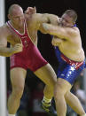 FILE - In this Sept. 27, 2000, file photo, Rulon Gardner, right, of the United States, holds the arm of Aleksandr Karelin, of Russia, during the final bout in the 130kg class of Greco-Roman wrestling event at the Summer Olympic Games in Sydney. An Olympic Channel documentary debuting Wednesday, July 22, 2020, chronicles the highs and lows of Rulon Gardner in the 20 years since his stunning gold-medal victory in the 2000 Olympics. (AP Photo/Katsumi Kasahara, File)