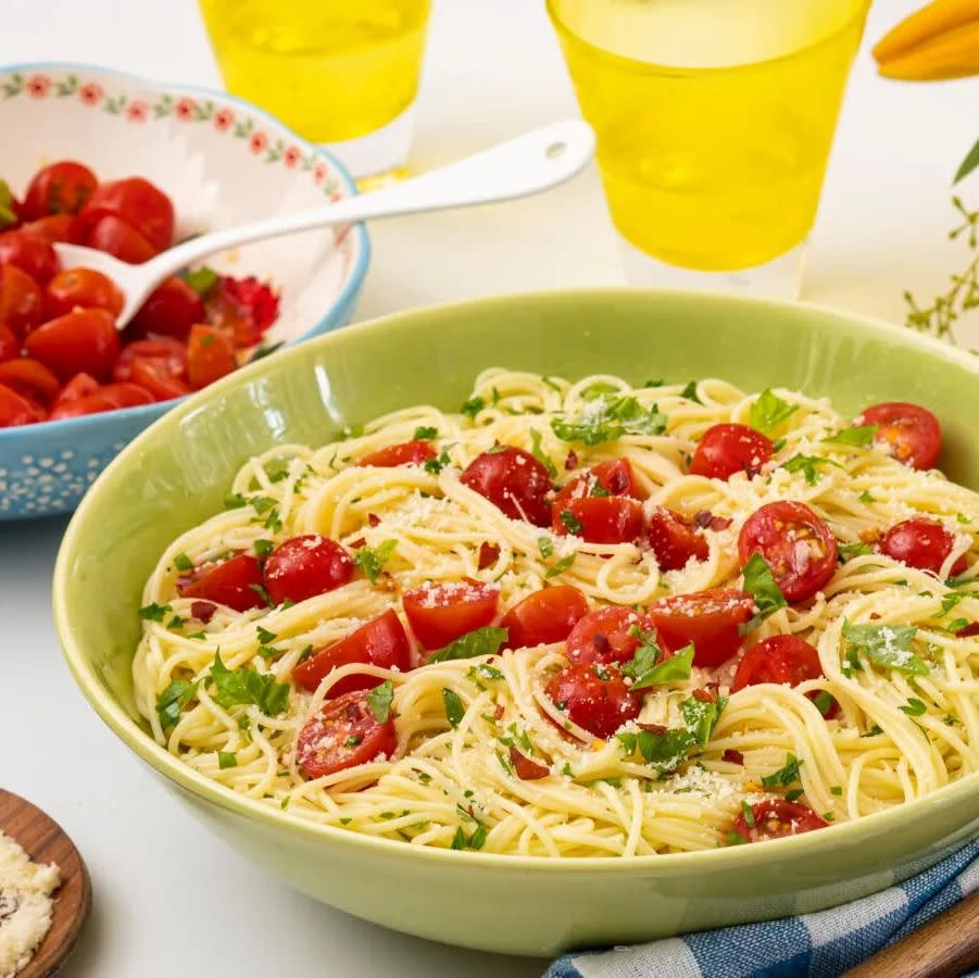 angel hair pasta with cherry tomatoes in green bowl