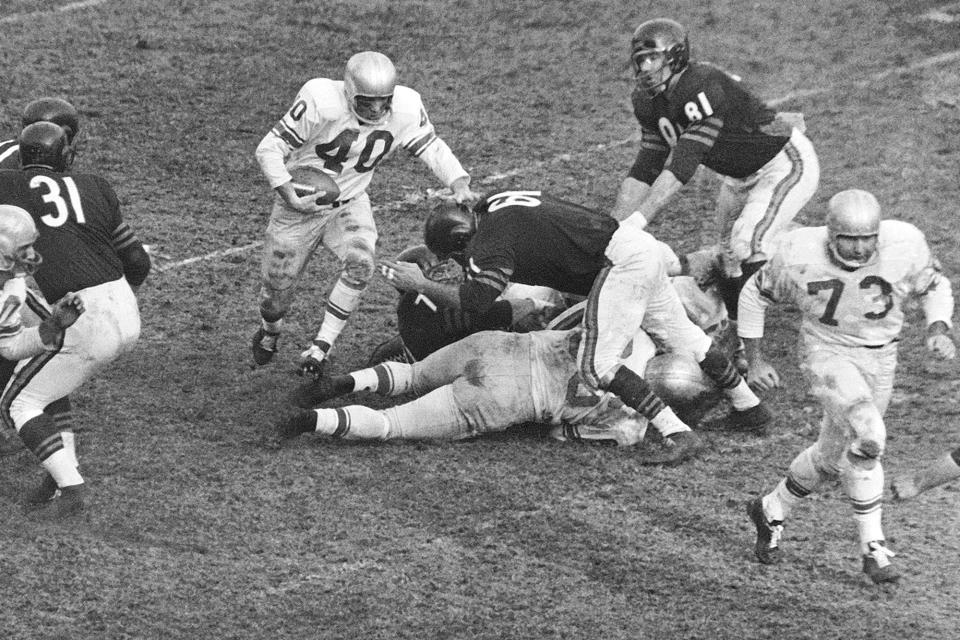 FILE - In this Dec. 14, 1959, file photo, Detroit Lions back Howard Cassady (40) shoots toward a big hole in the Chicago Bears defense during the third quarter of a football game Chicago, Ill. Cassady, a Heisman Trophy winner and former NFL running back, died early Friday, Sept. 20, 2019, in Tampa, Fla., Jerry Emig, the Ohio State associate athletic director said. He was 85. Cassady played both football and baseball at Ohio State in the early 1950s, winning the Heisman Trophy in 1955. He also played 10 seasons in the NFL, mostly with the Detroit, and got the nickname "Hopalong" from local sports writers after the black-hatted Western star of the 1950s. (AP Photo/Ed Maloney, File0