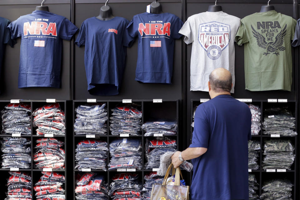 A convention attendee looks at NRA branded shirts for sale at the NRA Store at the NRA Annual Meeting held at the George R. Brown Convention Center Thursday, May 26, 2022, in Houston. (AP Photo/Michael Wyke)