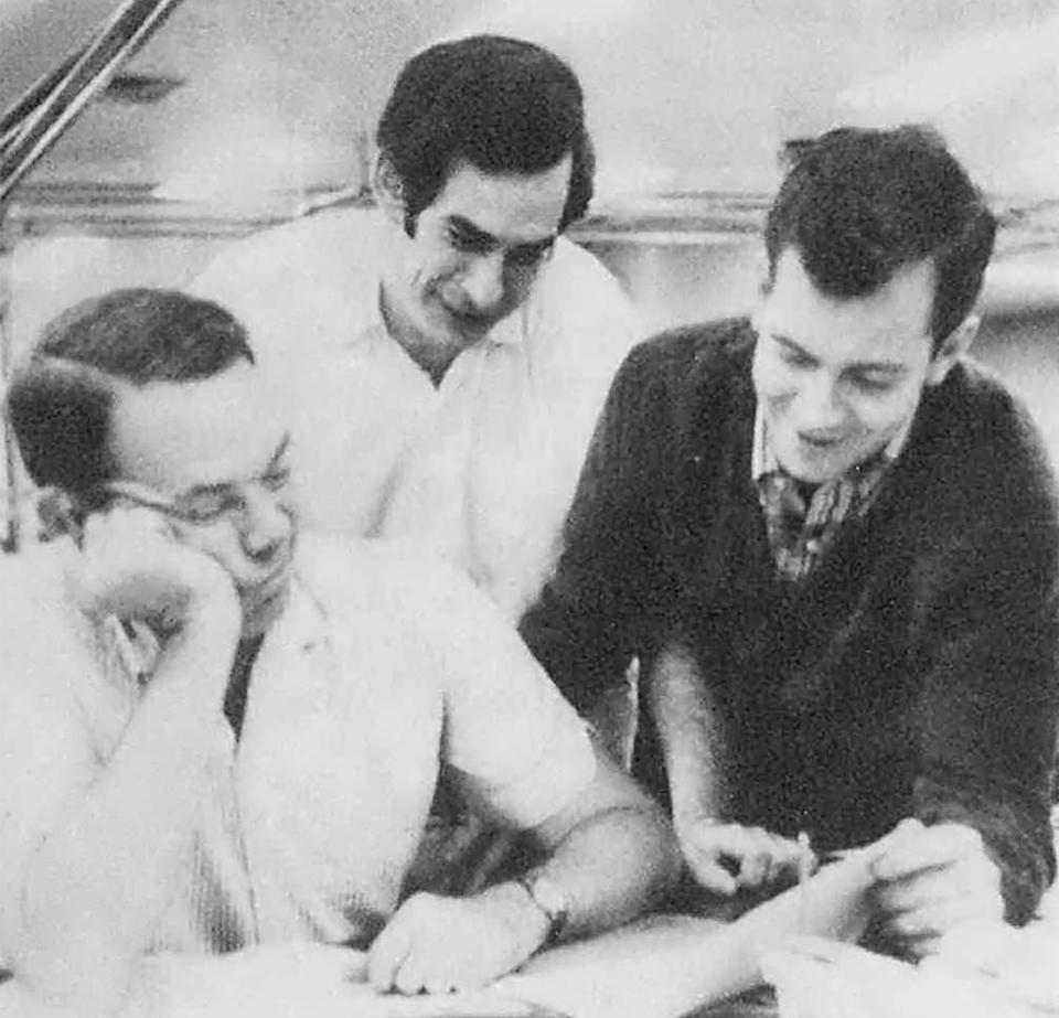 In this 1967 photo Associated Press staffers, from left, supervisor Harris Jackson, John Vinocur and Pat O’Keefe work on AP's international desk in New York. Vinocur, a much-respected foreign correspondent for The New York Times and The Associated Press and later executive editor and columnist at the International Herald Tribune in Paris, has died. His son told The New York Times that Vinocur died in Amsterdam on Sunday, Feb. 6, 2022, from complications from sepsis. He was 81. (AP Photo)