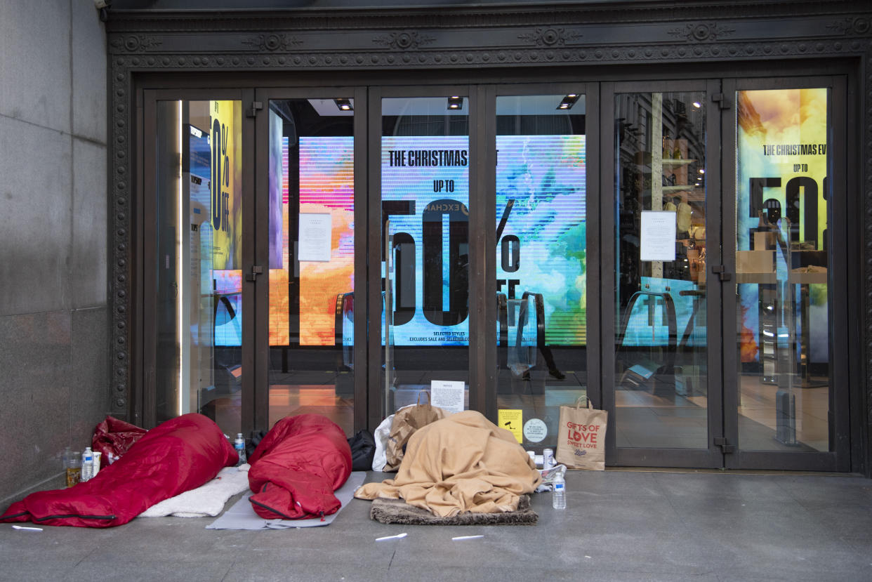 Three homeless people sleep in the doorway of Topshop, as new tier 4 coronavirus restrictions continue, to limit the spread,in Oxford Street, Central London, UK on Dec 24, 2020. Levels of coronavirus are continuing to rise with one in 85 people in England infected, according to the Office for National Statistics. London now has the highest percentage of people testing positive ,more than 2\%. Figures released for the week to 18 December estimate nearly 650,000 people have the virus, up from 570,000 the week before.(Photo by Claire Doherty/Sipa USA)