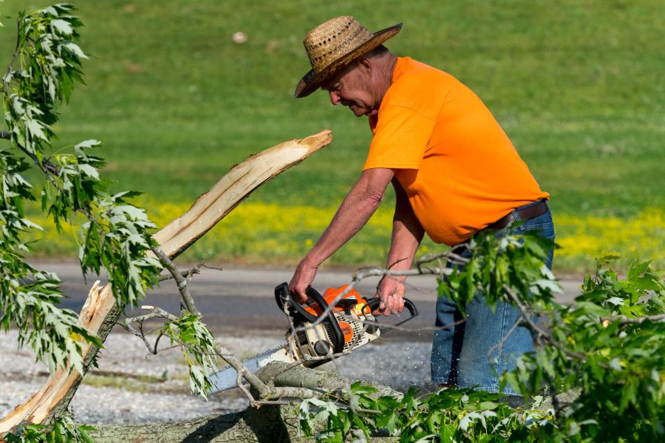 Bill Bates trims a down tree at his river camp Friday morning, May 20, 2022. Heavy storm winds came through Mount Carmel, Ill., Thursday night causing damage to the southend. 