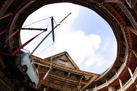 A camper van is lifted by a crane to be placed on the stage at London's Globe theatre June 17, 2007. REUTERS/Alessia Pierdomenico