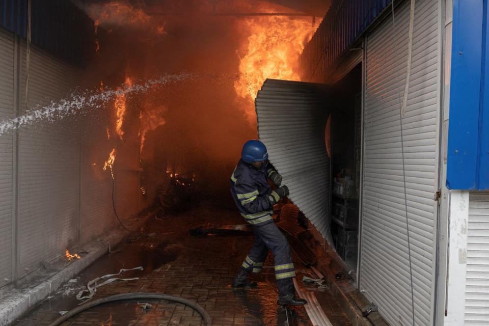 Firefighters spray water onto a blaze at a market in Sloviansk that was hit by shelling  (REUTERS)