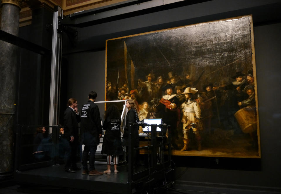 Technicians and researchers check equipment set up inside a glass chamber as they begin to study Rembrandt's 'Night Watch' masterpiece, at the Rijksmuseum in Amsterdam, Monday July 8, 2019. Researchers and restorers at Amsterdam's Rijksmuseum launched a months-long project Monday, using high-tech imaging technology to throw new light on Rembrandt van Rijn's iconic "Night Watch."(AP Photo/Aleksandar Furtula)