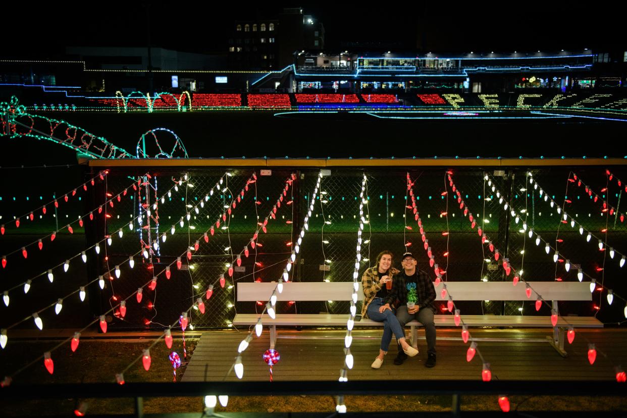 Emily and Galen Gant watch "The Santa Clause" movie on the scoreboard screen during the Fayetteville Holiday Lights event at Segra Stadium on Thursday, Dec. 8, 2022.