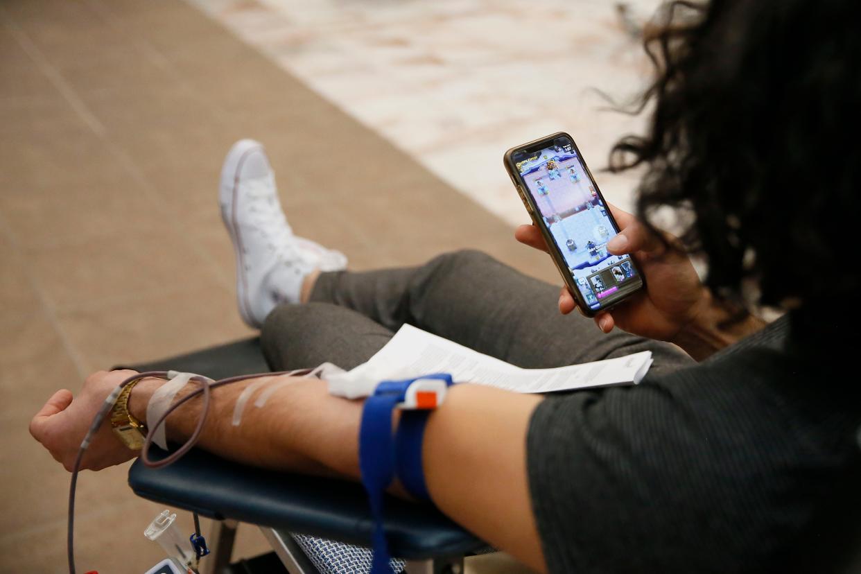 David Lepe plays a game on his phone while getting blood drawn during the blood drive at Sunland Park Mall in partnership with Vitalant in El Paso. Donors received a complimentary COVID-19 antibody test as part of their blood donation.