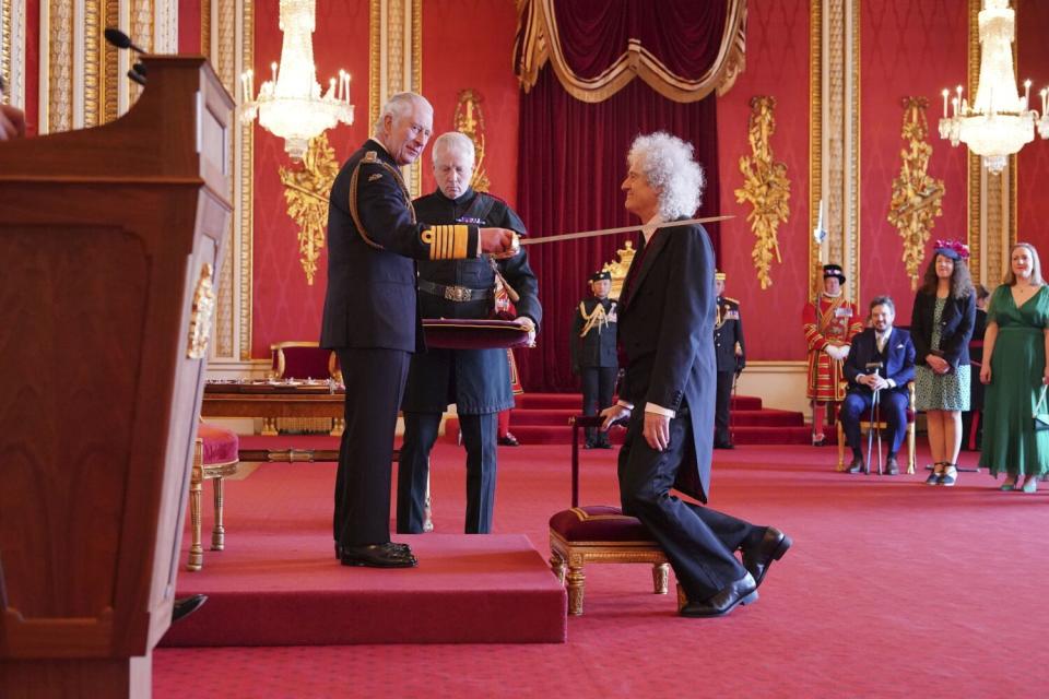 A man kneeling in front of a king inside a palace