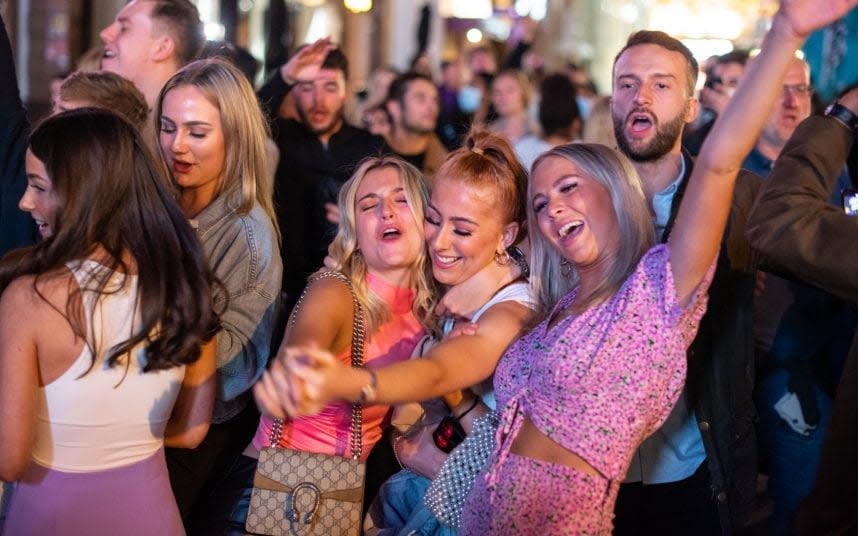 Last blowout: People sing and dance as they watch a street performer in London's Leicester Square before the 'rule of six' came into force - DOMINIC LIPINSKI/PA