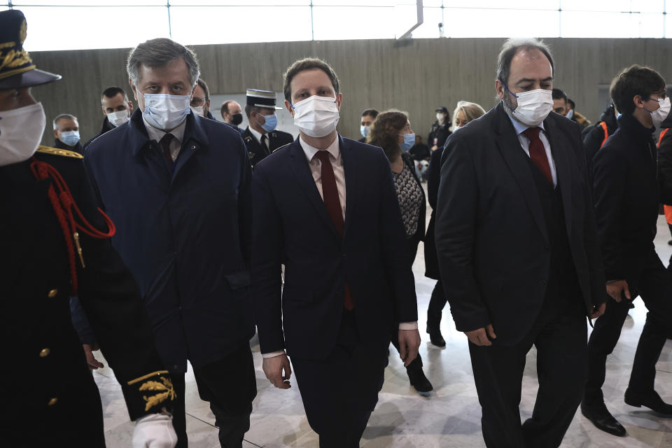 French Health Minister Francois Braun, right, French Junior Minister for Transports Clement Beaune, center, and French Aeroports de Paris (ADP) group CEO Augustin de Romanet, left, arrive to visit a COVID-19 testing area set for passengers arriving from China, at the Roissy Charles de Gaulle airport, north of Paris, Sunday, Jan. 1, 2023. France says it will require negative COVID-19 tests of all passengers arriving from China and is urging French citizens to avoid nonessential travel to China. (AP Photo/Aurelien Morissard)