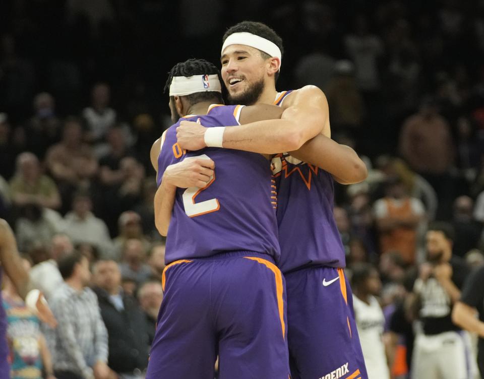 Phoenix Suns guards Devin Booker (1) and Josh Okogie (2) hug during the final seconds of the fourth quarter during a game against the Sacramento Kings at Footprint Center in Phoenix on Feb. 13, 2024. Suns won 130-125.