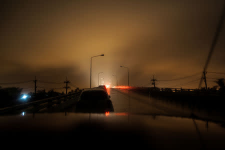 Light from cars is seen at a road without electricity as tropical storm Pabuk approaches the southern province of Nakhon Si Thammarat, Thailand, January 4, 2019. REUTERS/Krittapas Chaipimon