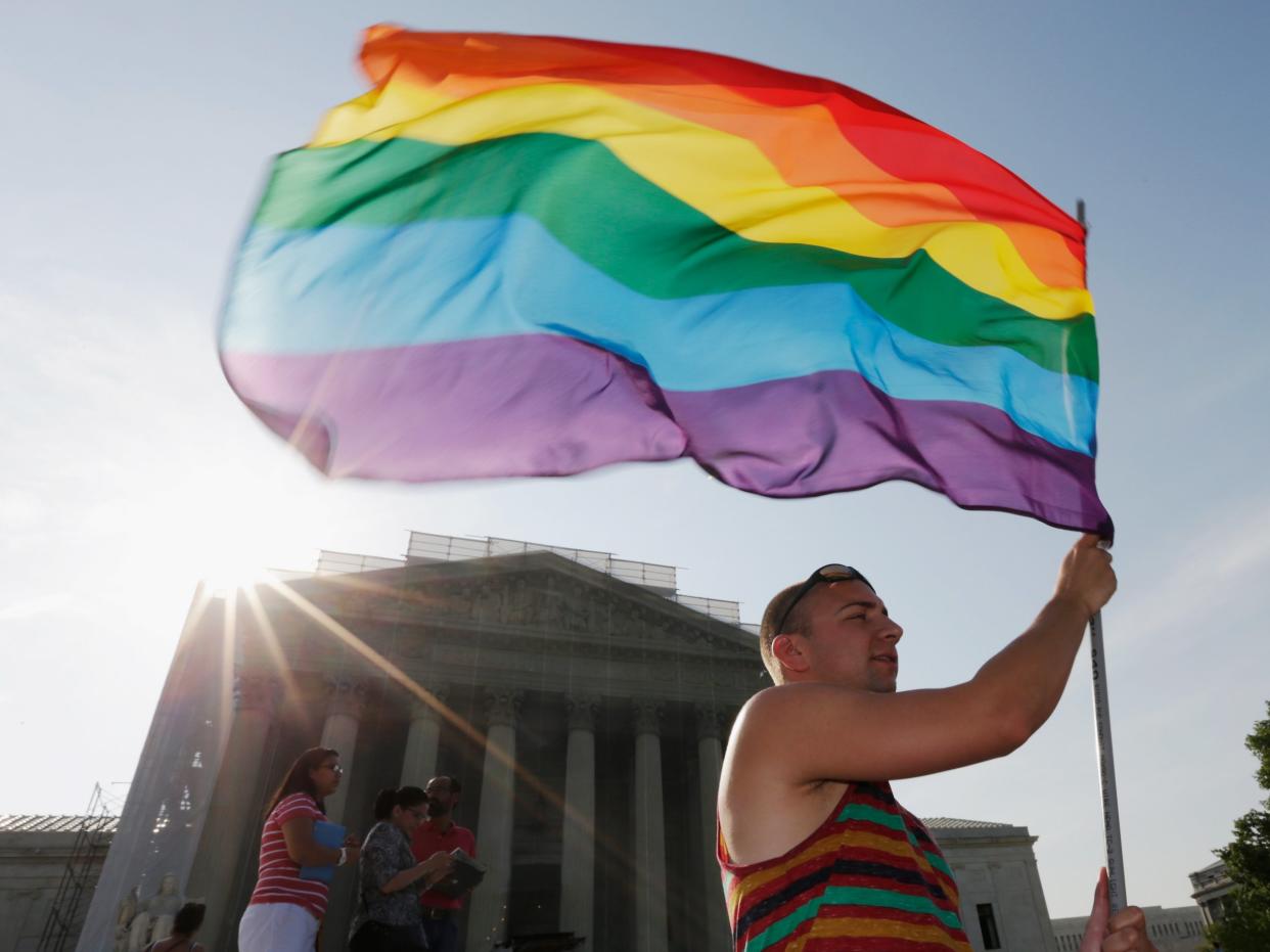 Man waving rainbow flag