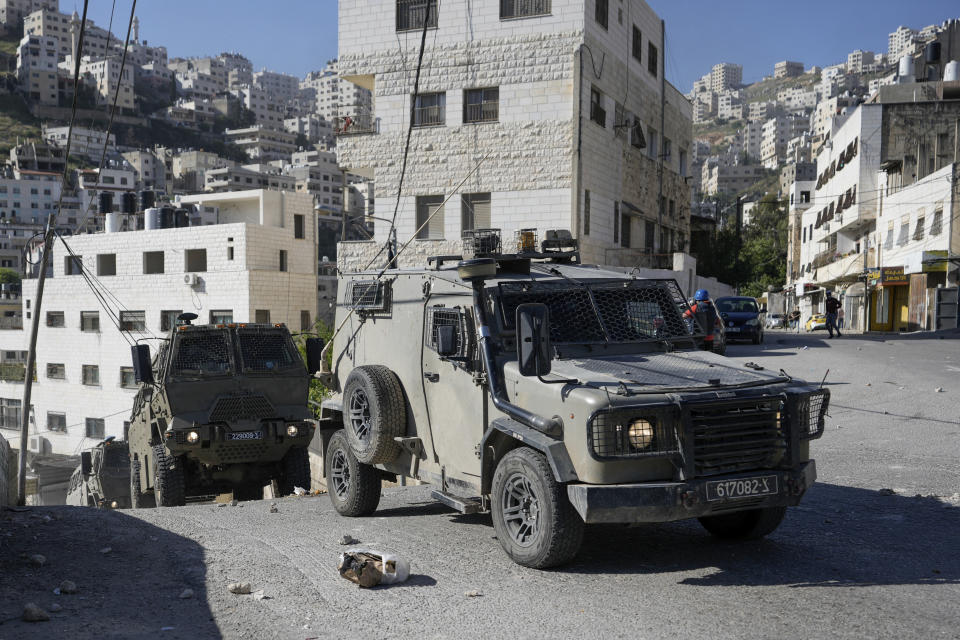 A convoy of Israeli military vehicles drives through the West Bank city of Nablus, during a raid, Thursday, May 4, 2023. The Israeli military says it has killed three Palestinians wanted for an attack last month on a car near a Jewish West Bank settlement that killed a British-Israeli mother and two of her daughters. The military says a fierce gunbattle erupted when the army entered the heart of the flashpoint city of Nablus early Thursday. (AP Photo/Majdi Mohammed)