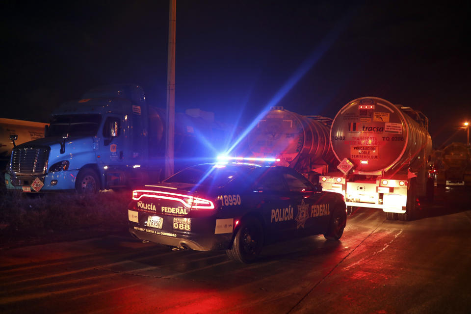 Una patrulla de la policía federal escolta camiones de gasolina mientras salen de un centro de distribución de Pemex en la ciudad de Veracruz, México, el miércoles 9 de enero de 2019. (AP Foto/Félix Márquez)
