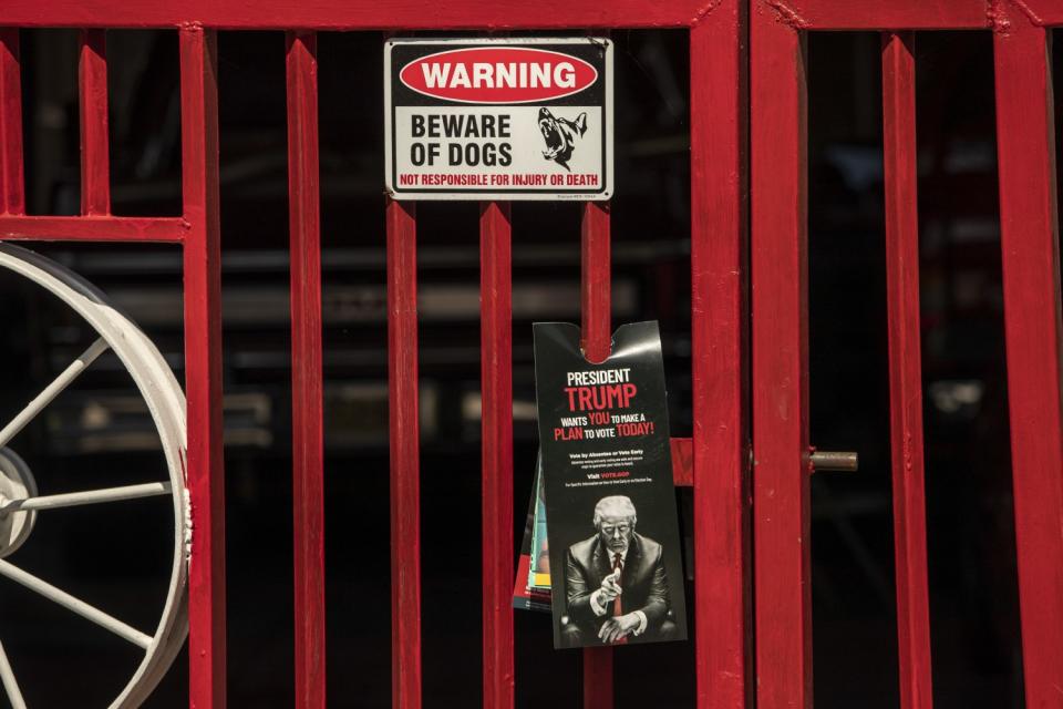 A door hanger with President Trump attached to a red fence