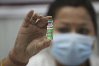 An Indian doctor shows a COVID-19 vaccine at a government Hospital in Jammu, India, Saturday, Jan.16, 2021. India started inoculating health workers Saturday in what is likely the world's largest COVID-19 vaccination campaign, joining the ranks of wealthier nations where the effort is already well underway.(AP Photo/Channi Anand)