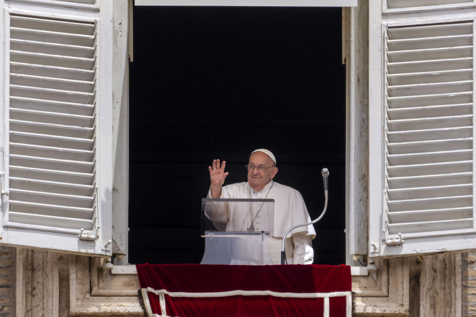 Pope Francis waves from his studiio's window overlooking St. Peter's Square at The Vatican, Sunday, June 9, 2024, where faithful and pilgrims gathered for the traditional Sunday's blessing at the end of the Angelus prayer. (AP Photo/Domenico Stinellis)