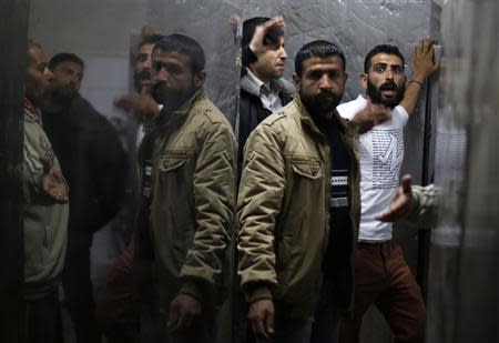 Palestinian relatives of Ibrahim Mansour, 26, who was killed by Israeli soldiers, react at a hospital morgue in Gaza City February 13, 2014. REUTERS/Suhaib Salem