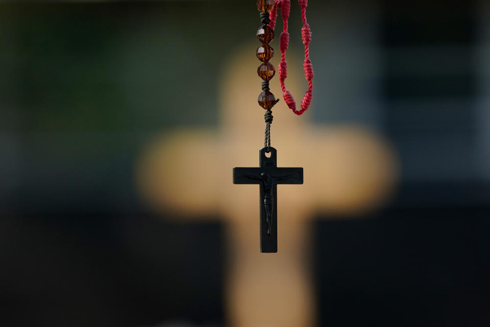 A rosary hangs at a make-shift memorial honoring the school shooting victims at Robb Elementary, Monday, July 11, 2022, in Uvalde, Texas. Students who survived the May 24 shooting at an elementary school in Uvalde, Texas are spending the summer grappling with post-traumatic stress disorder. Meanwhile, parents find themselves unable to help them, worried the tragedy at Robb Elementary struck a largely Hispanic town as Latinos continue to face disparities to access mental health care. (AP Photo/Eric Gay)