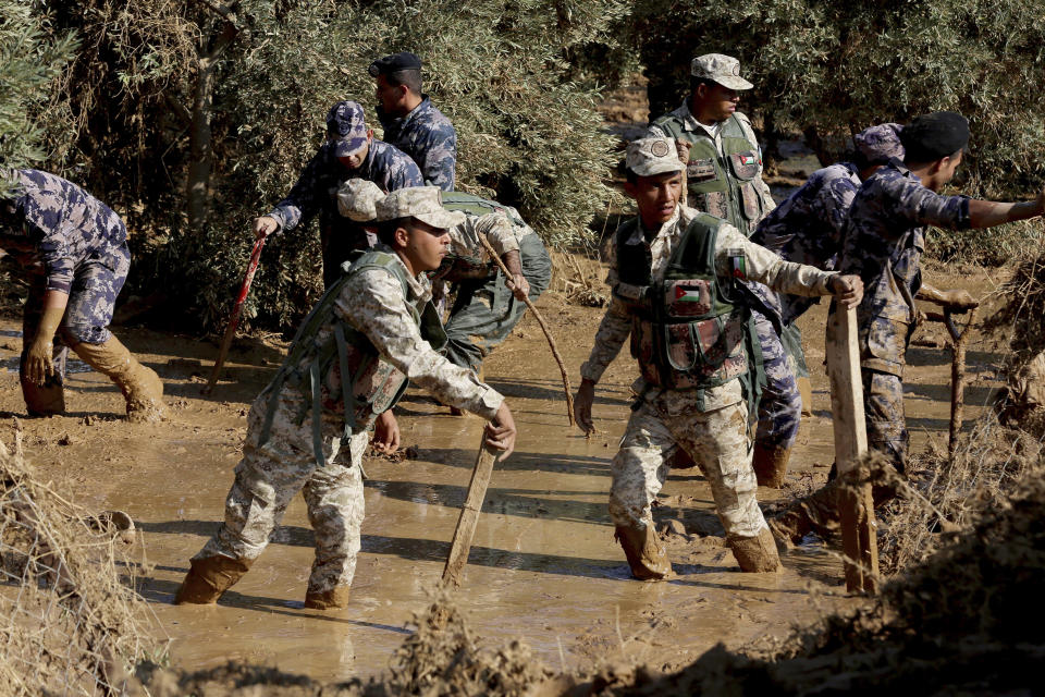 Jordanian rescue teams search Saturday, Nov. 10, 2018 for missing people in the Madaba area, south of the capital of Amman, after flash floods unleashed by heavy rain a day earlier killed at least 12 people. (AP Photo/Raad Adayleh)