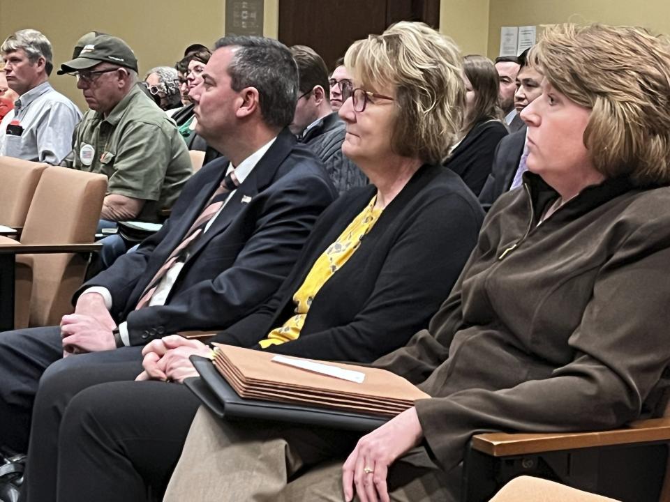 Three Nebraska election officials, from left to right, Douglas County Election Commissioner Brian Kruse, Seward County Election Commissioner Sherry Schweitzer and Hall County Election Commissioner Tracy Overstreet listen to testimony at a public hearing in Lincoln, Neb., at the state Capitol, Wednesday, March 1, 2023, on competing bills to address ways to enact a voter ID requirement approved by voters last November. (AP Photo/Margery Beck)