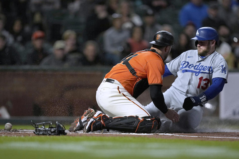 Los Angeles Dodgers' Max Muncy (13) slides into home plate to score past San Francisco Giants catcher Joey Bart, left, who drops the ball during the second inning of a baseball game Friday, Sept. 16, 2022, in San Francisco. (AP Photo/Tony Avelar)