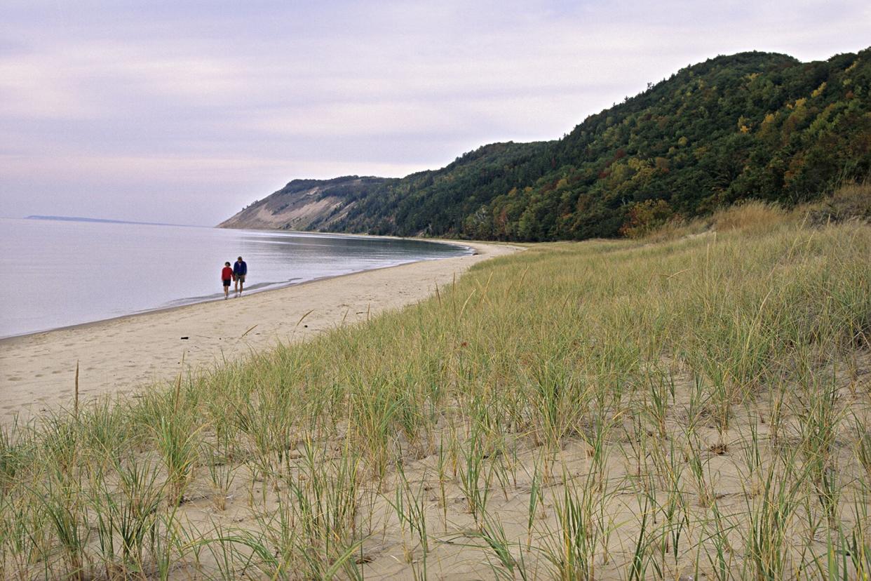 Couple walking along dune grass, Empire Bluff, Sleeping Bear Dunes National Lakeshore, Michigan, USA