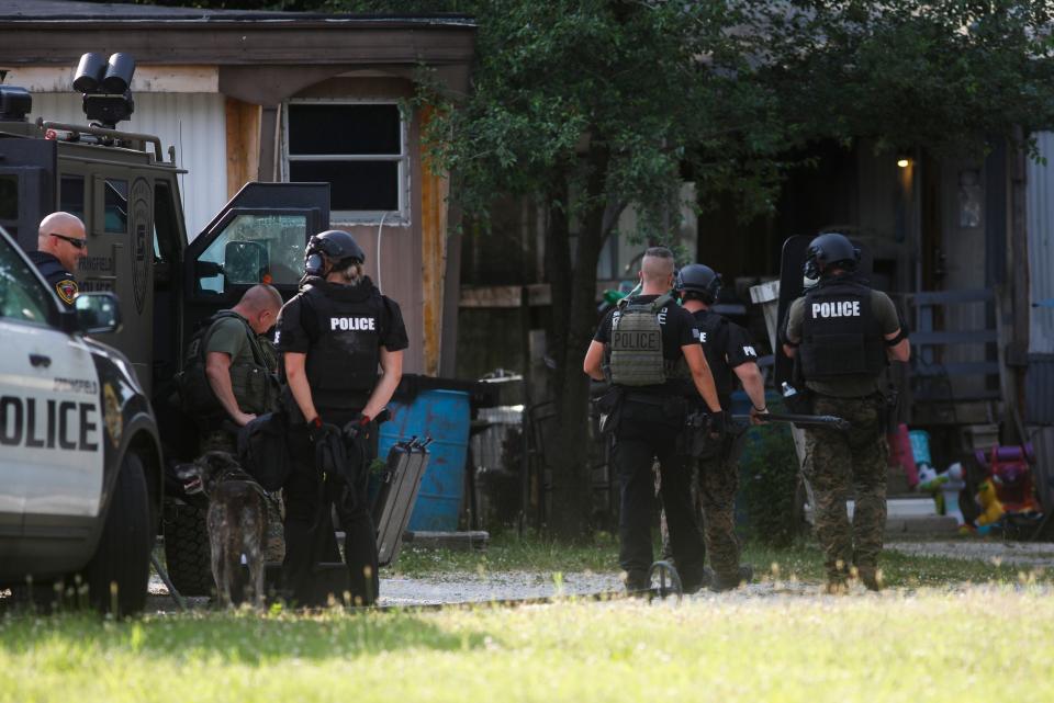 Springfield Police surround a mobile home on East Caravan Street near Glenstone Avenue on Wednesday evening. After a five-plus hour standoff, the man who was a suspect in a homicide was found dead inside the home.