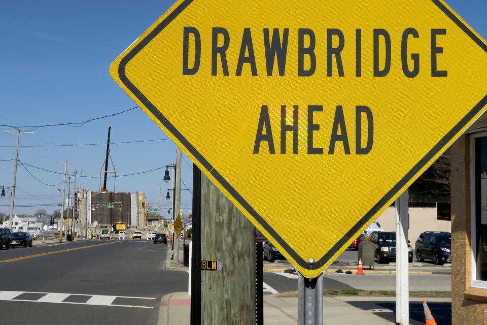 A crane holds the north leaf of the Route 71 bridge over the Shark River, in this view north along Main Street in Belmar Tuesday, March 12, 2024. The bridge was stuck in the closed position, blocking boat access to the ocean.