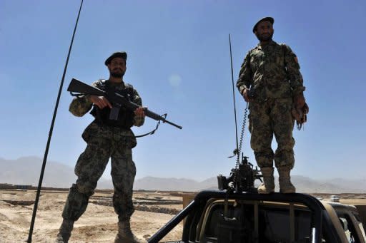 Afghan National Army soldiers stand guard near the body of an insurgent who was killed along with four others planning a suicide attack in the capital Kabul on August 2, 2012