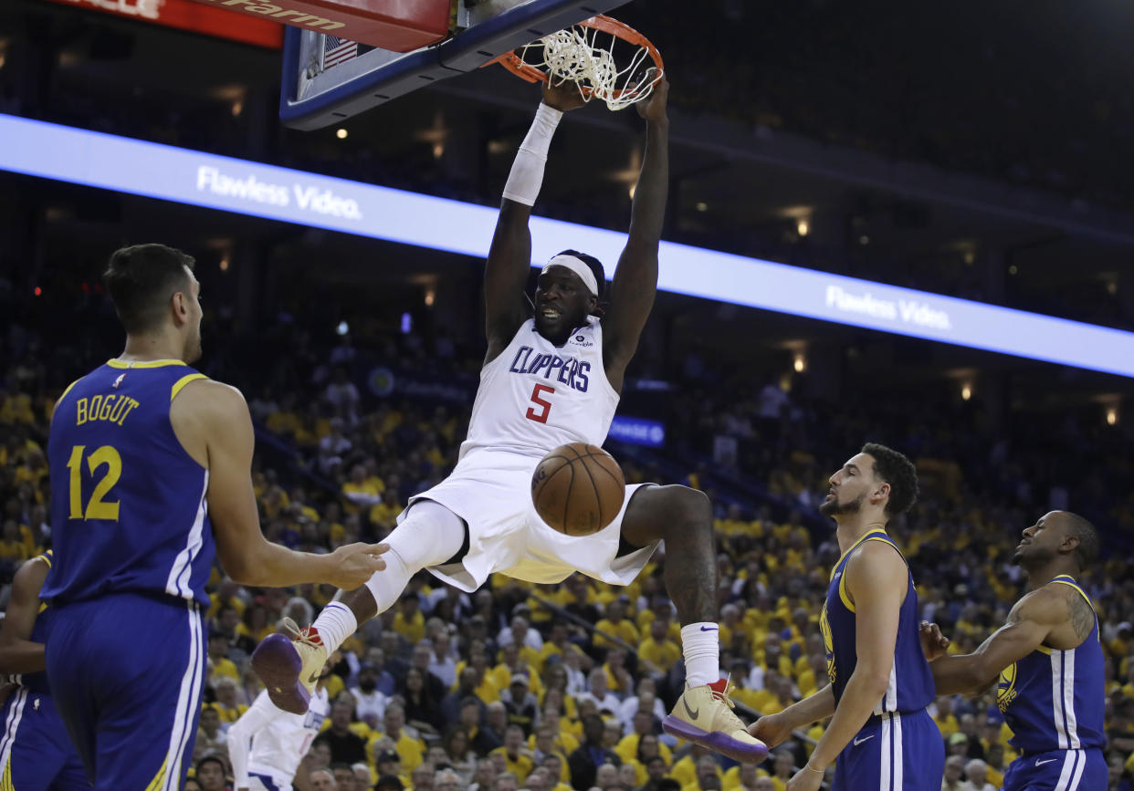 Los Angeles Clippers' Montrezl Harrell (5) scores as Golden State Warriors' Andrew Bogut (12), Klay Thompson, second from right, and Andre Iguodala watch during the second half in Game 5 of a first-round NBA basketball playoff series, Wednesday, April 24, 2019, in Oakland, Calif. (AP Photo/Ben Margot)