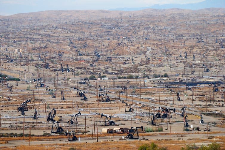 A California oil field dotted with derricks.