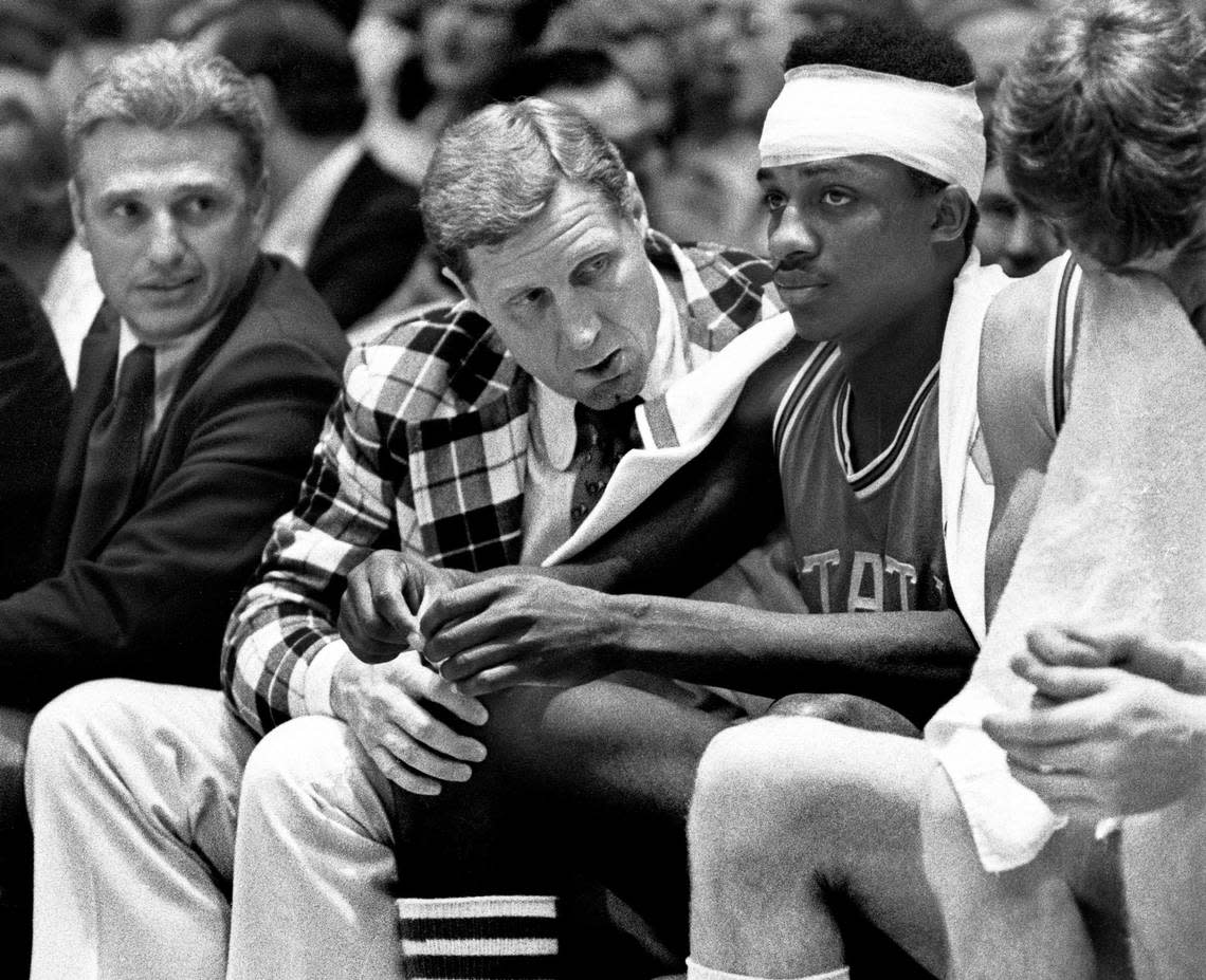 NC State coach Norm Sloan talks to an injured David Thompson after he returned to the game from the hospital. Thompson took a terrible fall against Pittsburgh, but returned for the Wolfpack victory.