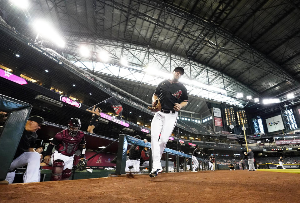 Under a Chase Field roof that cannot be opened with fans in the venue, Diamondbacks starting pitcher Merrill Kelly takes the field to face the San Francisco Giants on July 6.