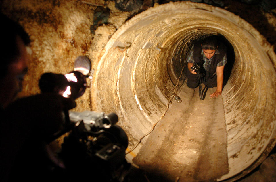 File-This July 8, 2004 file photo shows a Mexican federal agent crawls through a hidden tunnel, presumably used to transport drugs from Mexico to the U.S. The job of searching these networks can be dangerous, so the U.S. Border Patrol is unveiling its latest technology in the underground war, a wireless, camera-equipped robot that can do the job in a fraction of the time. (AP Photo/David Maung)