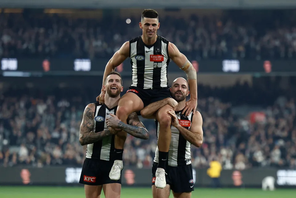 MELBOURNE, AUSTRALIA - AUG 03: Scott Pendlebury of the Magpies is chaired from the field after his 400th match by teammates Jeremy Howe (left) and Steele Sidebottom (right) during the 2024 AFL Round 21 match between the Collingwood Magpies and the Carlton Blues at The Melbourne Cricket Ground on August 03, 2024 in Melbourne, Australia. (Photo by Michael Willson/AFL Photos via Getty Images)