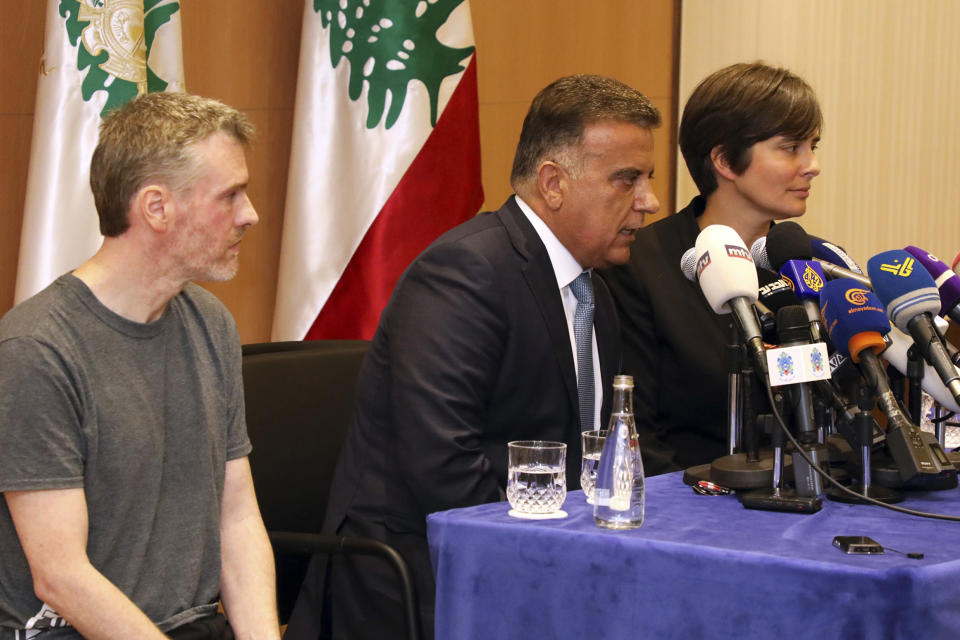 This handout photo by the Lebanese General Security Directorate, shows Maj. Gen. Abbas Ibrahim, left, Lebanon's General Security Chief, speaking flanked by Canadian citizen Kristian Lee Baxter, on his right and Canadian ambassador to Lebanon, Emmanuelle Lamoureux, on his left, during a press conference in Beirut, Lebanon, Friday, Aug 9, 2019. Baxter held in Syrian prisons since last year and freed after Lebanese mediation said Friday he had no idea if anyone knew he was still alive. The Lebanese general who mediated his release said Baxter was heading home. It was not clear when Baxter was released from Syria. (The Lebanese General Security Directorate via AP)