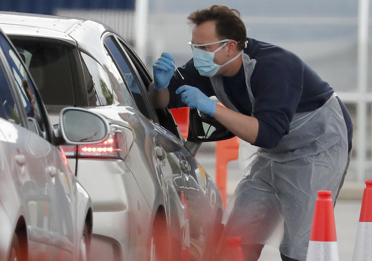 Staff work at a the COVID-19 testing facility at Ikea near the Wembley stadium in London, Wednesday, April 29, 2020. Coronavirus testing is now available for more people in England from Wednesday as the government relaxed rules on eligibility. (AP Photo/Frank Augstein)