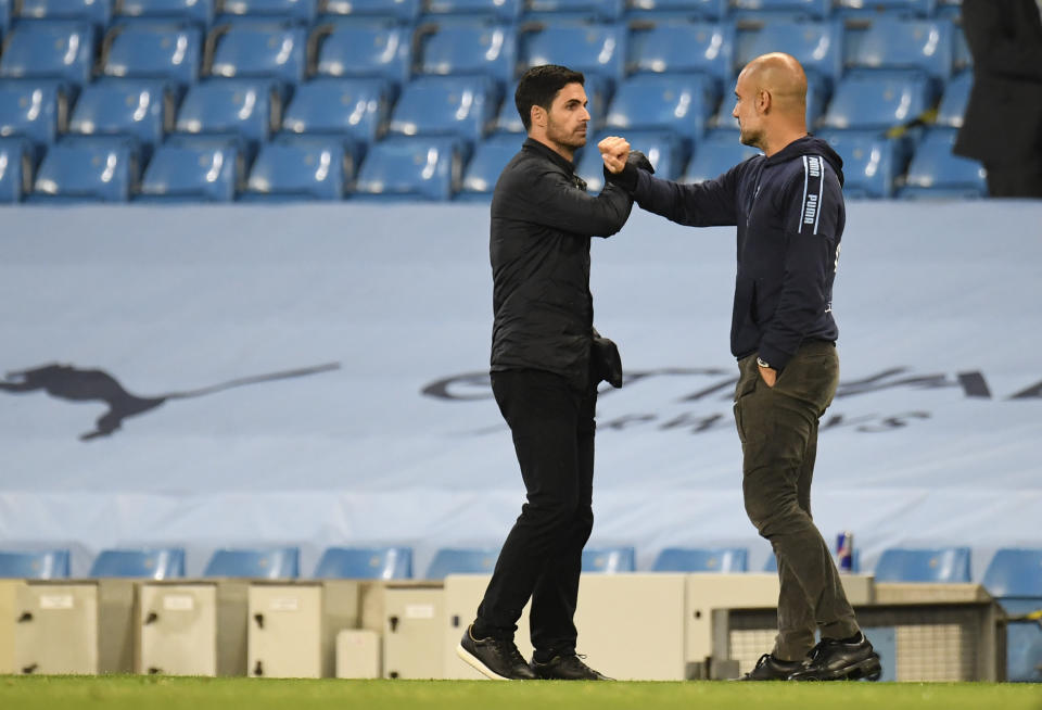 Arsenal's head coach Mikel Arteta, left, greets Manchester City's head coach Pep Guardiola after the English Premier League soccer match between Manchester City and Arsenal at the Etihad Stadium in Manchester, England, Wednesday, June 17, 2020. Manchester City won the match 3-0. The English Premier League resumes Wednesday after its three-month suspension because of the coronavirus outbreak. (Peter Powell/Pool via AP)