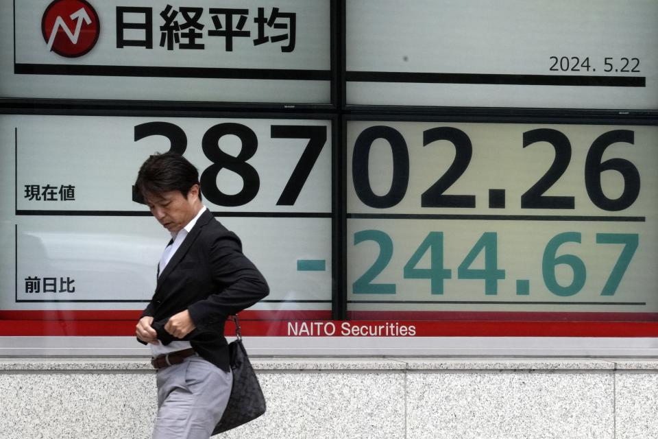 A person walks in front of an electronic stock board showing Japan's Nikkei 225 index at a securities firm Wednesday, May 22, 2024, in Tokyo. (AP Photo/Eugene Hoshiko)