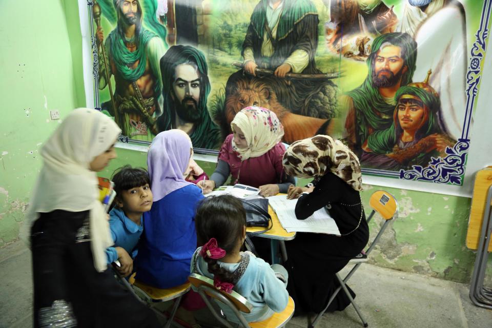 In this Thursday, March 13, 2014 photo, girls study at an orphanage in Baghdad, Iraq, Thursday, March 13, 2013. The director of the shelter says that she will not allow to marriage of minors at her orphanage, despite a contentious civil status draft law for Iraqi Shiite community that allows child marriage and restricts women’s rights that has stirred up a row among many Iraqis who see it as a setback for child and women rights, threatening to add more divisions and woos to the society that is already in fragments. (AP Photo/Karim Kadim)